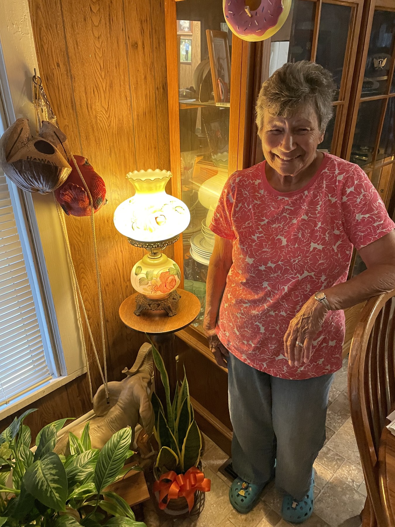 Grandma smiling at home beside a glowing lamp